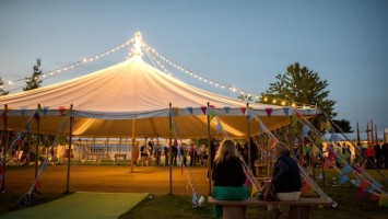 Hay festival open sided marque with festoon in the evening