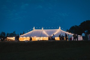 Traditional canvas wedding marquee at night with festoon lighting