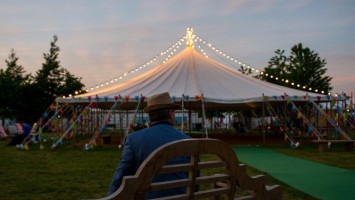 Traditional canvas marquee at a festival with white festoon lighting